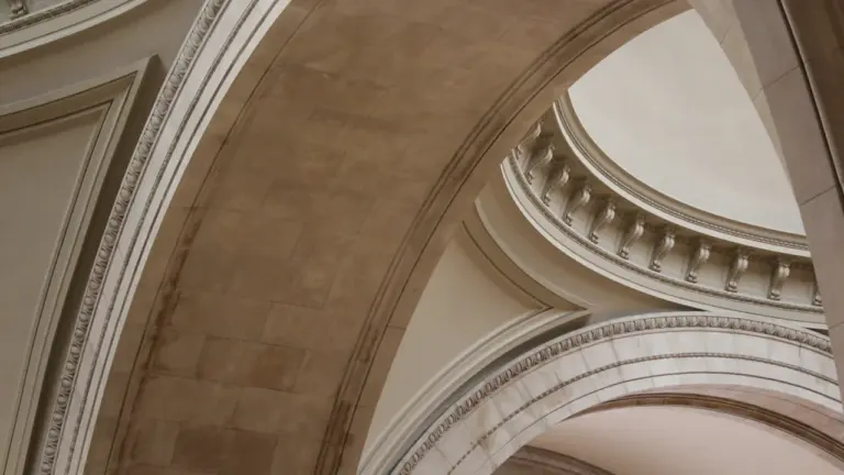 Historyczne wnętrze gdańskiego muzeum z charakterystycznymi łukami i klasyczną architekturą.